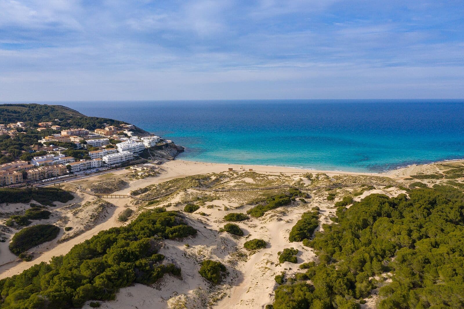 Vista aérea de Cala Mesquida, com a praia, as dunas e a água turquesa