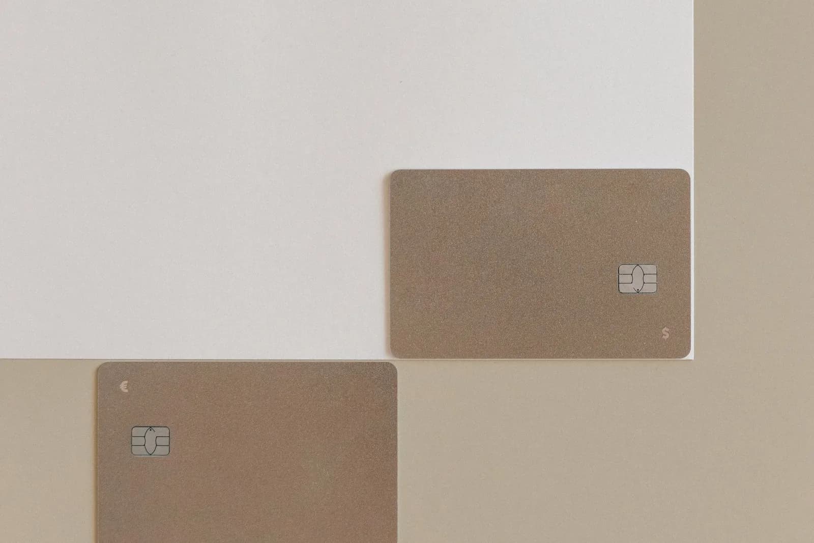 Zwei allgemeine Zahlungskarten mit Euro- und Dollarsymbol auf hellem Untergrund; Kartendaten sind nicht sichtbar.