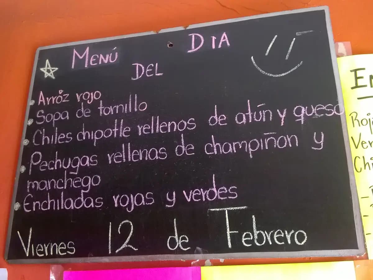 Ardoise noire avec le « menú del día » écrit à la craie dans un restaurant au Mexique, avec plusieurs plats et la date.