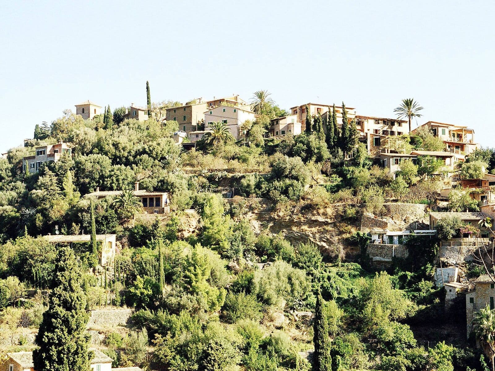 Stone houses of Deià among greenery on a hillside of the Serra de Tramuntana
