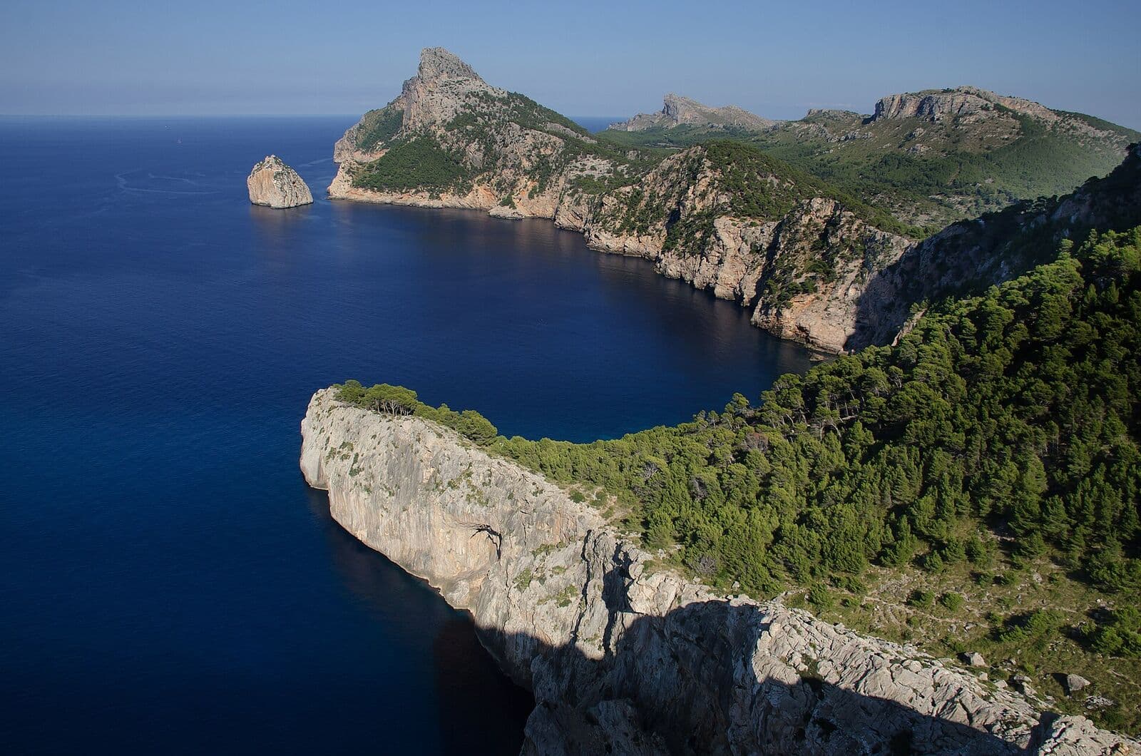 The Formentor cliffs and Es Colomer islet above a deep blue sea, with pine-covered slopes
