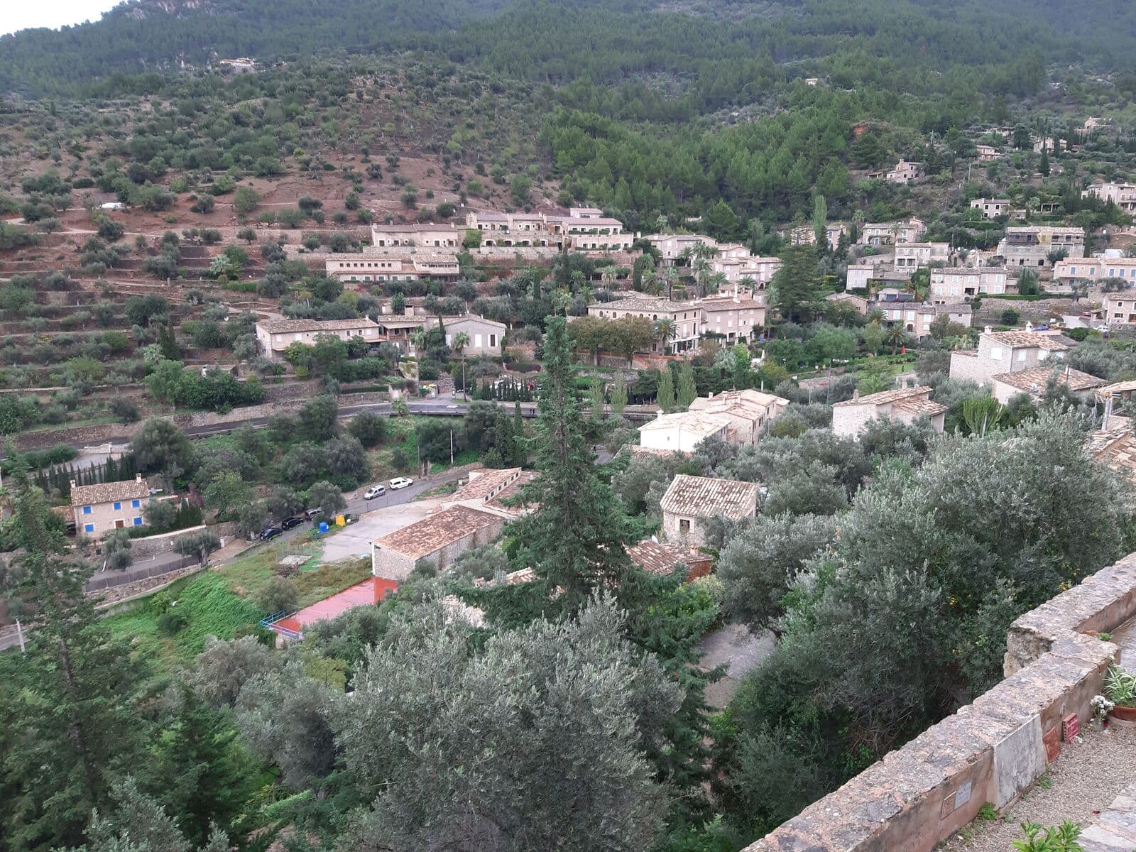 Casas de pedra de Deià entre oliveiras e terraços, na encosta da Serra de Tramuntana