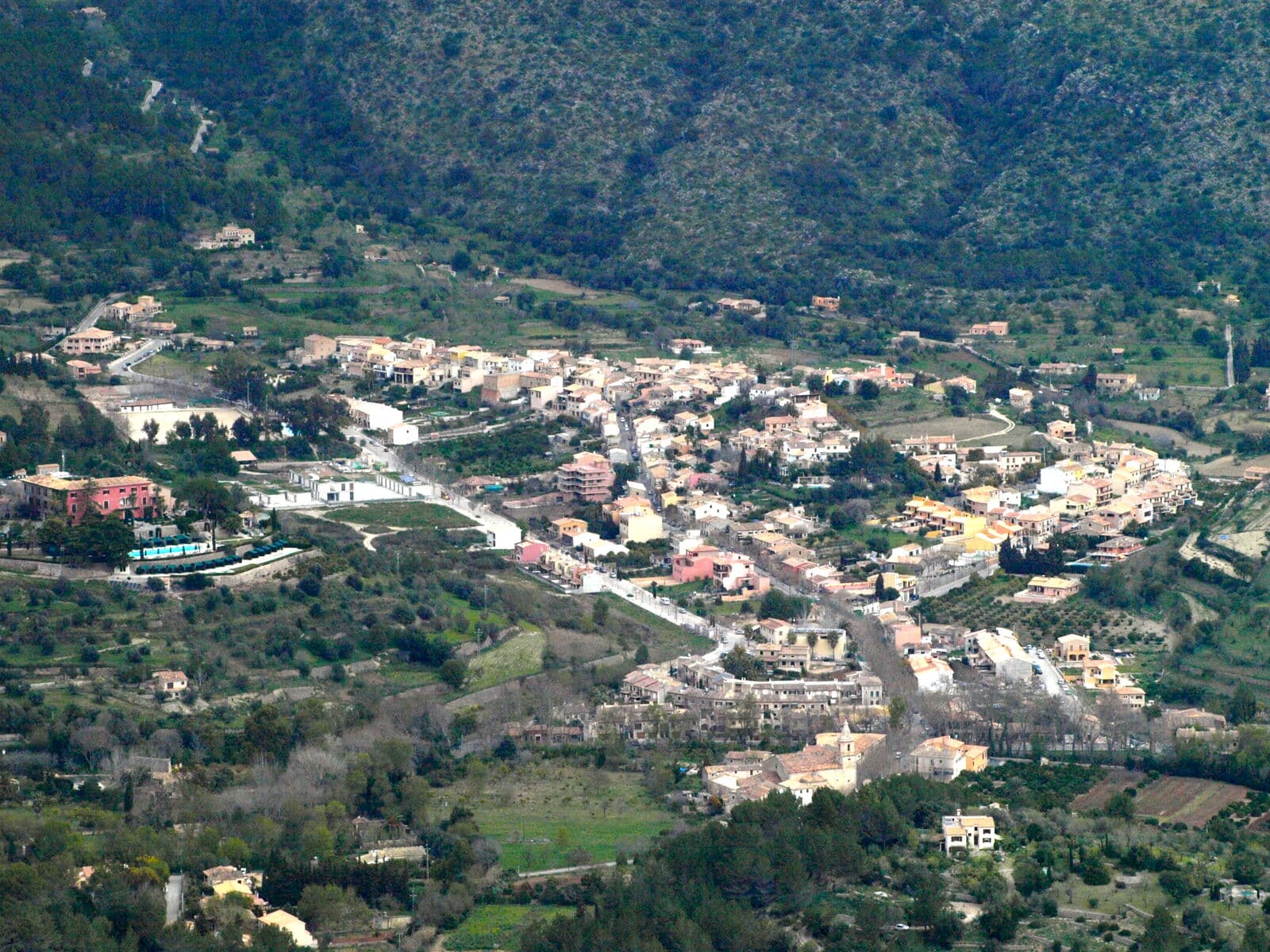 Il paese di Puigpunyent in una valle verde circondata da montagne boscose