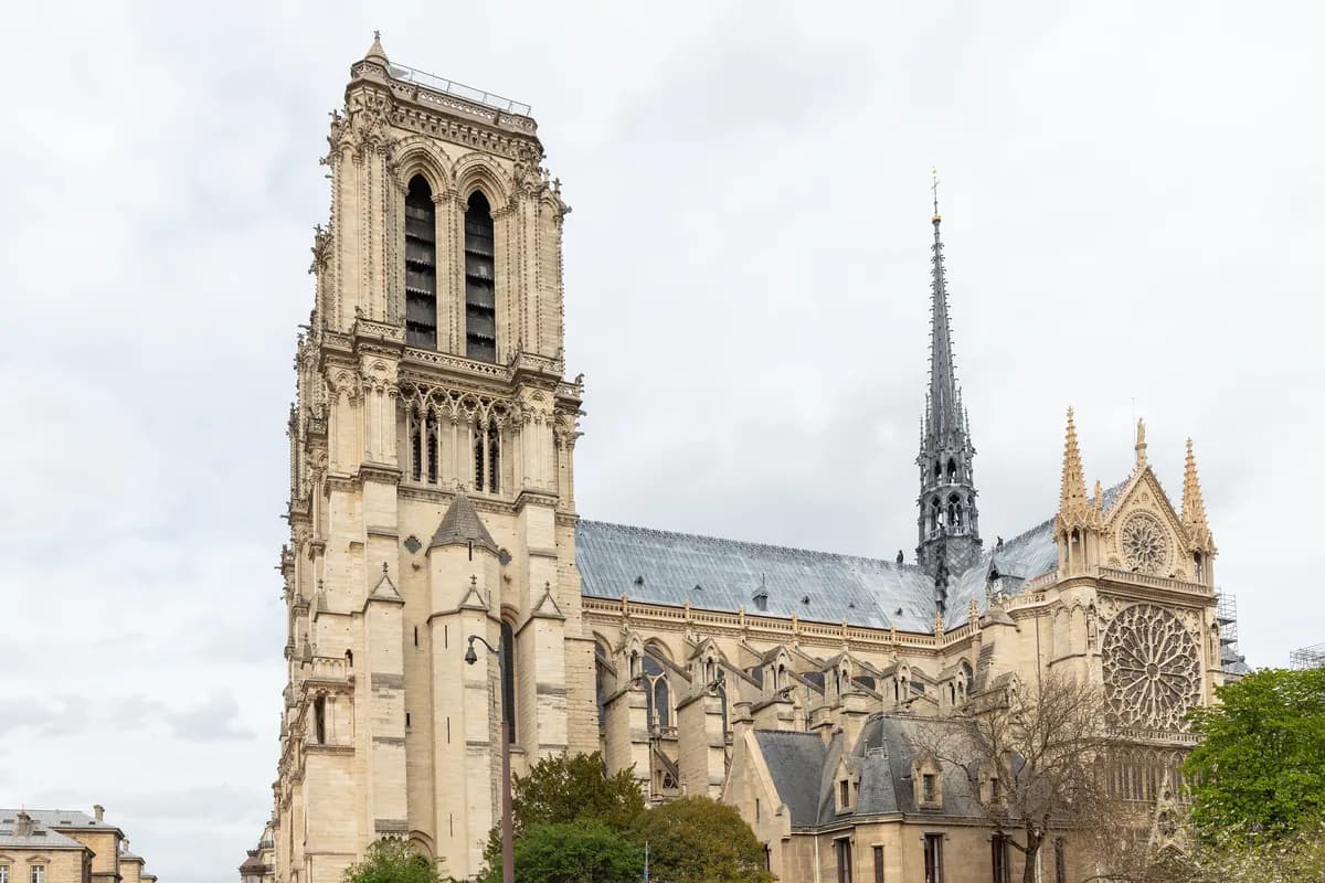 South tower and rebuilt spire of Notre-Dame Cathedral in Paris, photographed by day in April 2026.