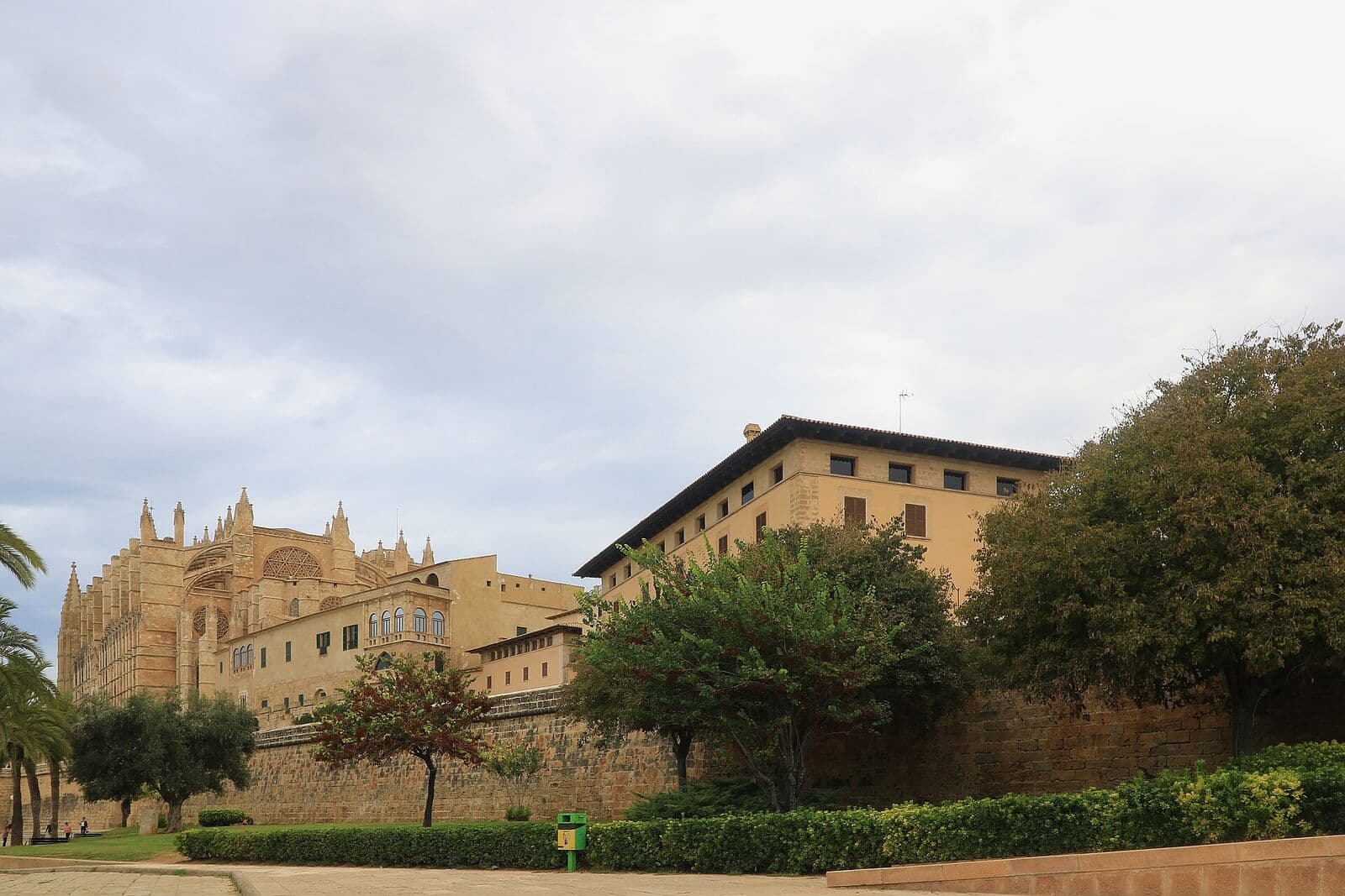 A catedral de Palma junto às muralhas do centro histórico, com árvores e jardins em primeiro plano
