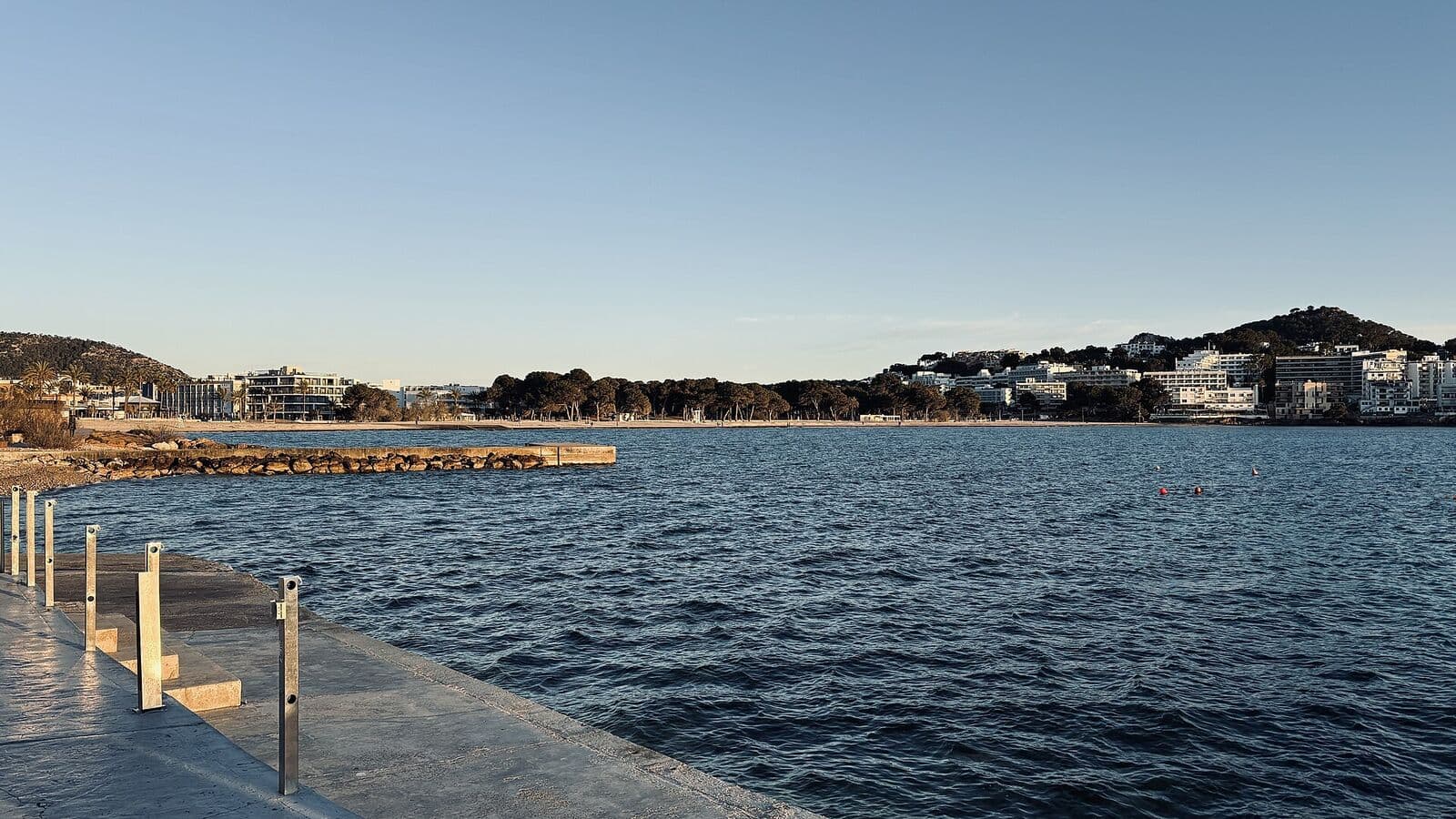 A baía de Santa Ponça com um passeio à beira-mar e edifícios baixos na margem oposta