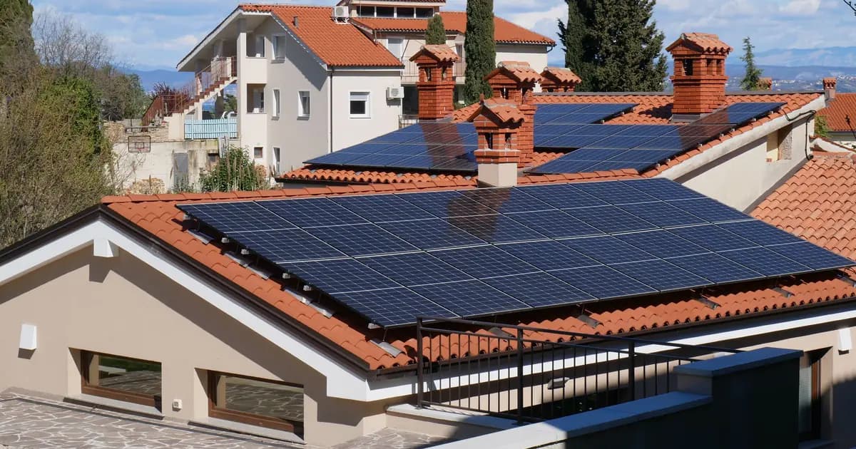Home with solar photovoltaic panels on a red-tiled roof.