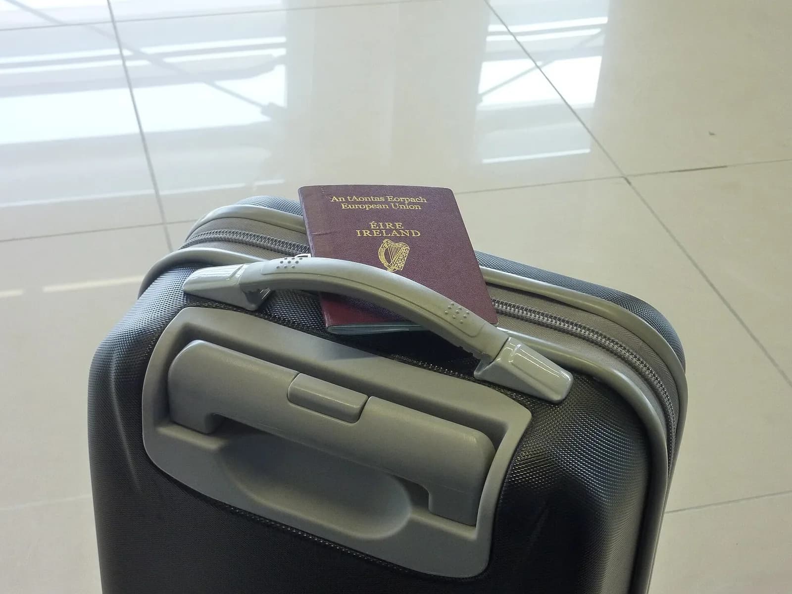 Maleta de cabina junto a un pasaporte en una zona pública del aeropuerto de Dubrovnik.