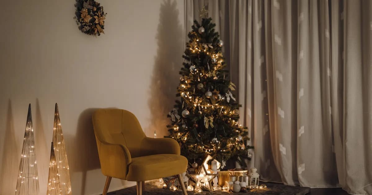 Lit Christmas tree in a corner beside a mustard armchair and light cones.