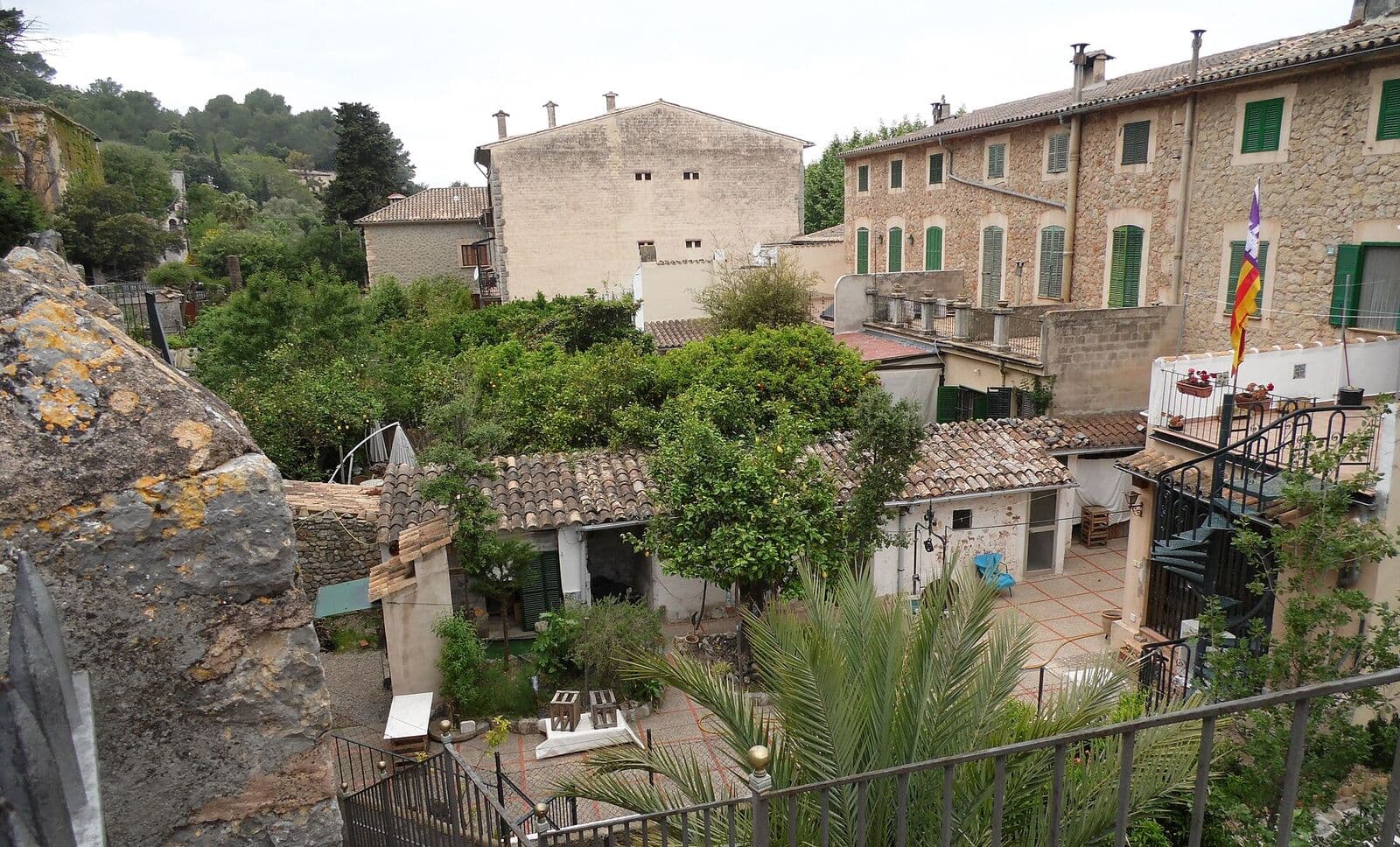 Casas de pedra com venezianas verdes e jardins em Valldemossa